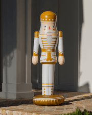 Decorative 3.5 foot inflatable nutcracker figure with gold and white design on a stone surface.